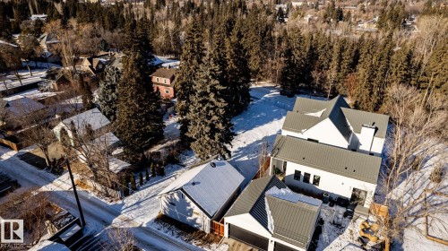 Modern dwelling featuring a white exterior, dark metal roofing, and a prominent chimney - 14307 Summit Drive, Edmonton, AB 