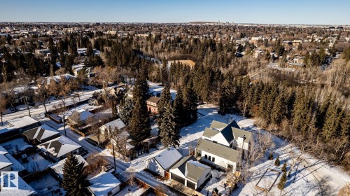 Aerial perspective of a residential area featuring a prominent white residence with dark roofing - 14307 Summit Drive, Edmonton, AB 