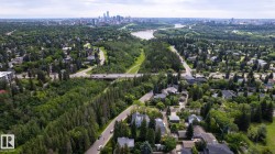Aerial perspective showcasing residential areas amidst extensive green spaces, a winding river, and a distant city skyline - 