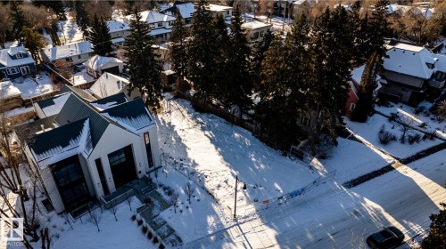 Modern white-sided residence featuring a dark metal roof, multi-level entrance steps, and prominent vertical window accents - 14307 Summit Drive, Edmonton, AB 