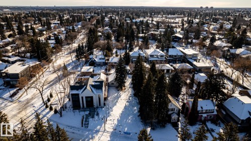 Aerial overview of a residential neighborhood with varied architectural styles, mature trees, and snow-covered grounds - 14307 Summit Drive, Edmonton, AB 