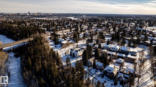Residential area featuring diverse architectural styles, mature trees, a bridge structure, and a distant cityscape - 14307 Summit Drive, Edmonton, AB 