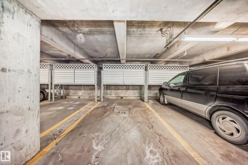 Covered parking space featuring concrete flooring and overhead lighting - 108 12028 103 Avenue, Edmonton, AB 