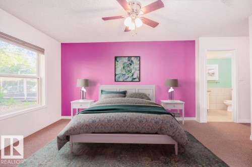 Bedroom featuring a prominent accent wall and a window offering outdoor scenery - 108 12028 103 Avenue, Edmonton, AB 