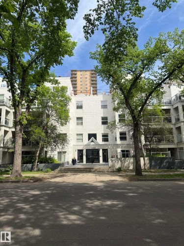 Multi-story building featuring a white facade and dark entry doors - 108 12028 103 Avenue, Edmonton, AB 