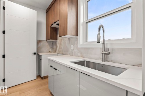 Light wood-finish flooring with white slab door - 13111 187 Avenue Nw, Edmonton, AB - Indoor Photo Showing Kitchen