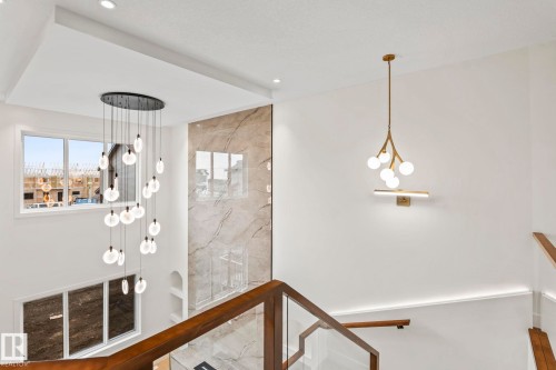 Multilevel ceiling with recessed lighting, a contemporary chandelier, and a decorative wall panel - 13111 187 Avenue Nw, Edmonton, AB - Indoor Photo Showing Other Room