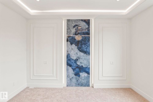 Tray ceiling with integrated lighting, recessed lighting, accent wall with backlighting, wall paneling, and carpet flooring - 13111 187 Avenue Nw, Edmonton, AB - Indoor Photo Showing Other Room