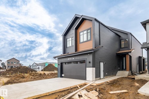 Contemporary exterior featuring dark horizontal siding and wood-finish accent panels - 13111 187 Avenue Nw, Edmonton, AB - Outdoor