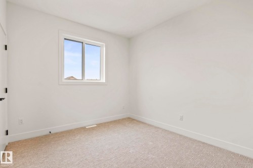 White walls with contrasting white trim, neutral carpeting, and a sliding window - 13111 187 Avenue Nw, Edmonton, AB - Indoor Photo Showing Other Room