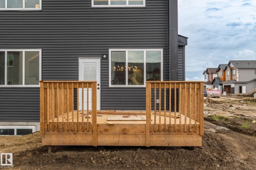 Rear exterior featuring horizontal siding, white-framed windows, and a wood deck with railings - 13111 187 Avenue Nw, Edmonton, AB - Outdoor