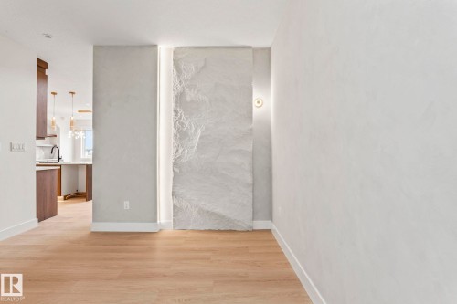 Wood-finish flooring throughout, with a textured accent wall and integrated linear lighting - 13111 187 Avenue Nw, Edmonton, AB - Indoor Photo Showing Other Room