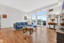 Spacious living area featuring wood-finish flooring, ample natural light, and a sliding glass door providing balcony access - 