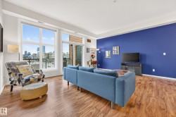 Living area featuring wood-finish flooring, a vibrant accent wall, and high ceilings - 