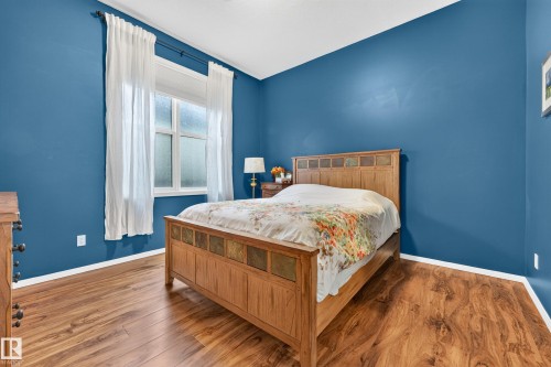 Room featuring wood-finish flooring, a window with white trim, and a white baseboard - 410 10531 117 Street, Edmonton, AB 