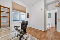 Room featuring wood-finish flooring, white walls, and a large window with privacy glass - 