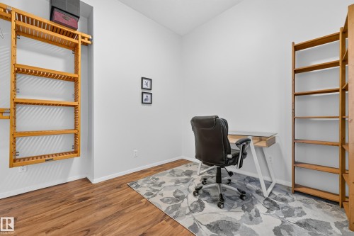 Versatile room featuring wood-finish flooring, white walls, and recessed lighting - 410 10531 117 Street, Edmonton, AB 