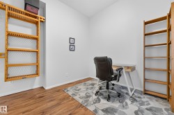 Versatile room featuring wood-finish flooring, white walls, and recessed lighting - 