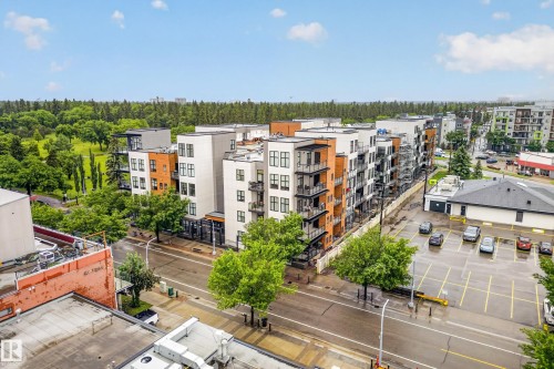Modern multi-story building featuring white and wood-tone facade elements, black-framed windows, and private balconies - 410 10531 117 Street, Edmonton, AB 