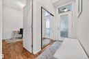 Entryway featuring wood-finish flooring, a full-lite door with frosted glass, and a transom window - 410 10531 117 Street, Edmonton, AB 
