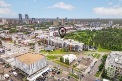 Aerial view of a city landscape featuring diverse urban architecture, a prominent park area with mature trees, and multiple residential and commercial structures - 
