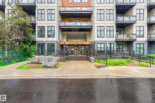 Contemporary building exterior featuring light-colored siding and dark brick accents - 410 10531 117 Street, Edmonton, AB 