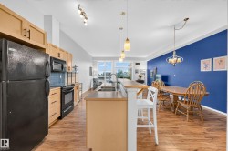 Open-concept kitchen and dining area featuring wood-finish flooring - 