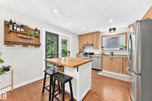 Kitchen with wood-finish flooring and light wood cabinetry - 15146 Ramsay Crescent, Edmonton, AB 