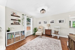 Spacious room featuring wood-finish flooring, light-toned wall paint, and a ceiling-mounted light fixture - 