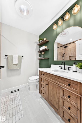 Bathroom featuring a wood-finish vanity with a white countertop and integrated sink - 15146 Ramsay Crescent, Edmonton, AB 