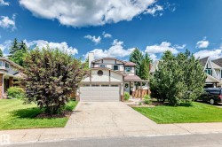 Exterior featuring a two-car garage, concrete driveway, and front lawn - 