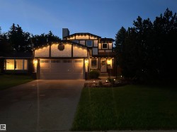 Tudor-style exterior featuring stucco and dark trim, a two-car garage, and a concrete driveway - 