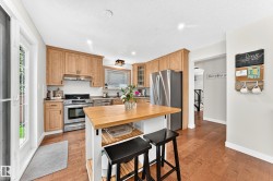Kitchen featuring light wood cabinetry, stainless steel appliances, and a central island with a wood countertop - 