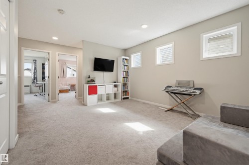Spacious carpeted room featuring multiple windows, recessed lighting, and white trim - 56 Springbrook Wynd, Spruce Grove, AB - Indoor