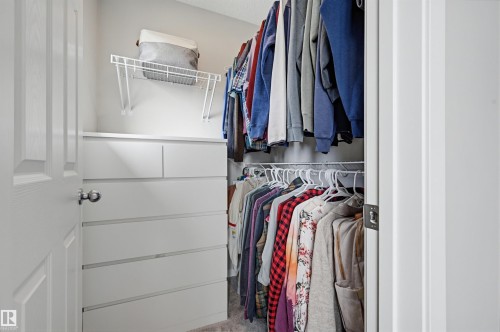 Custom closet organization system featuring white built-in drawers, a wire shelf, and multiple hanging rods - 56 Springbrook Wynd, Spruce Grove, AB - Indoor With Storage