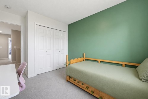 Bedroom featuring a single accent wall in a muted green hue, light gray carpeting, and a white bi-fold closet - 56 Springbrook Wynd, Spruce Grove, AB - Indoor Photo Showing Bedroom