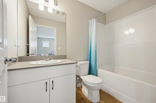 Bathroom featuring a white vanity with gray countertop, integrated sink, and brushed nickel faucet - 56 Springbrook Wynd, Spruce Grove, AB - Indoor Photo Showing Bathroom