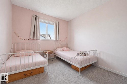 Bedroom featuring a double window, light-colored carpeting, and painted walls - 56 Springbrook Wynd, Spruce Grove, AB - Indoor Photo Showing Bedroom