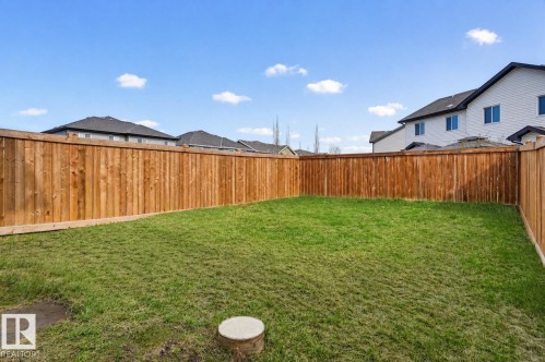 Expansive backyard featuring a new wood privacy fence and a manicured lawn - 56 Springbrook Wynd, Spruce Grove, AB - Outdoor