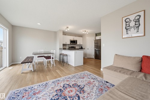 Open-concept living space featuring wood-finish flooring, recessed lighting, and a sliding glass door - 56 Springbrook Wynd, Spruce Grove, AB - Indoor