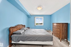 Bright room featuring a window with exterior views, light blue walls, and a textured ceiling - 