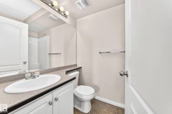 Bathroom vanity with an integrated sink, laminate countertop, and white cabinetry - 