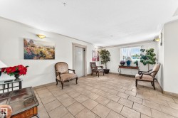 Spacious interior with neutral-toned rectangular floor tiles and white baseboards - 