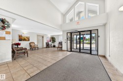 Spacious lobby featuring vaulted ceilings with high windows, glass entry doors, and durable tile flooring - 