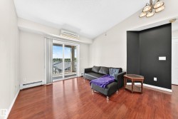 Bright living area featuring wood-finish flooring, a contemporary ceiling light fixture, a split air conditioning unit, and a glass sliding door leading to an outdoor balcony - 
