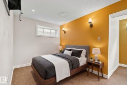 Bedroom featuring warm-toned accent wall with sconce lighting - 