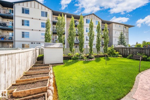 Expansive green space featuring a manicured lawn, a paved patio, and mature landscaping - 39 Meadowview Court, Spruce Grove, AB 