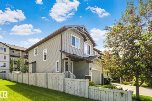 Contemporary townhouse exterior featuring horizontal siding, white trim windows, a covered entry, and an attached garage - 39 Meadowview Court, Spruce Grove, AB 
