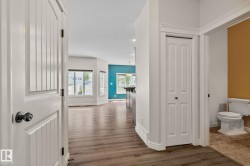 Wood-finish flooring throughout, bright white trim, and a prominent bay window - 