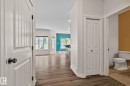 Wood-finish flooring throughout, bright white trim, and a prominent bay window - 39 Meadowview Court, Spruce Grove, AB 